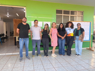 Pessoas em pé diante de uma parede verde