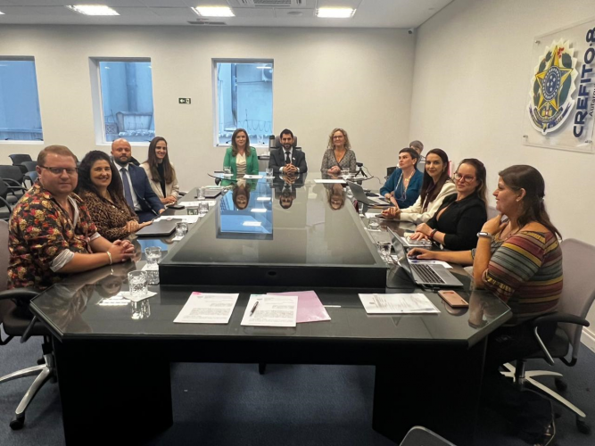 Foto da mesa da reunião com secretária Leandre no Crefito