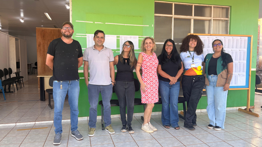 Pessoas em pé diante de uma parede verde